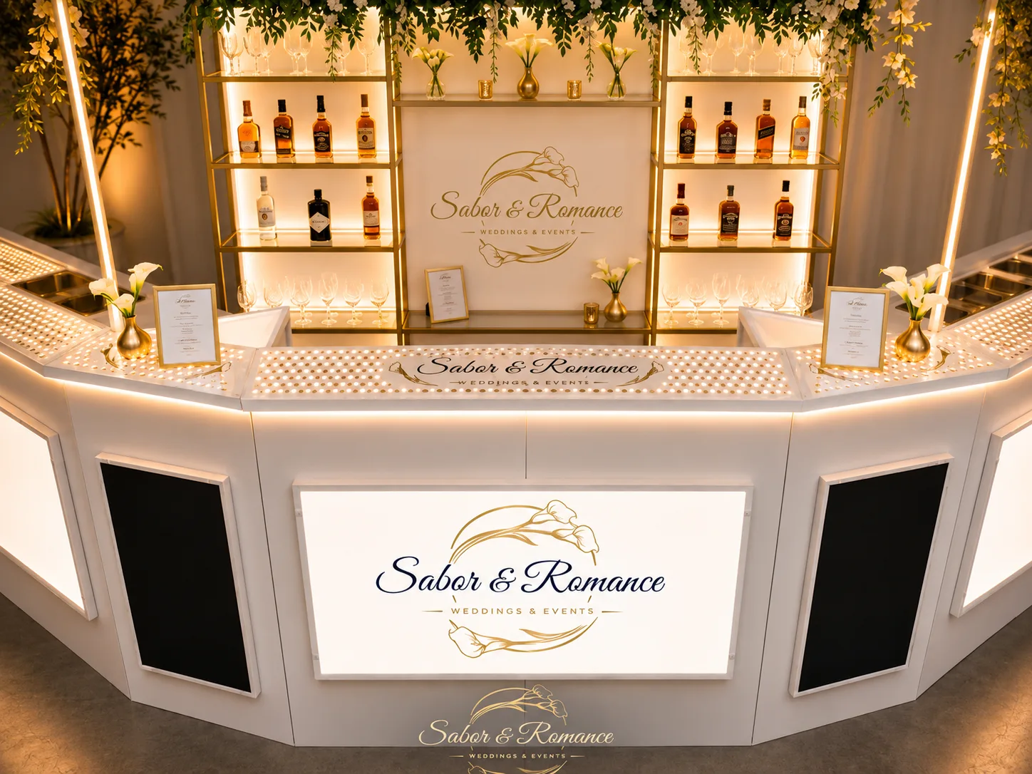 Barra blanca con estanterías doradas, botellas premium y flores